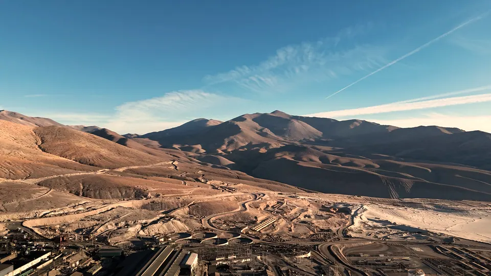 Faena minera en el desierto con la cordillera al fondo