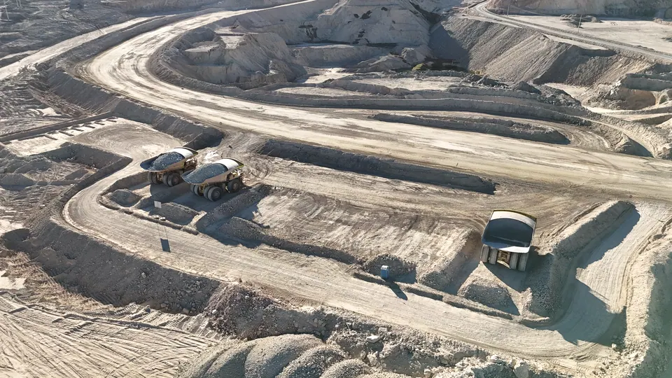 Camiones de extracción en los caminos de un rajo, vistos desde un dron